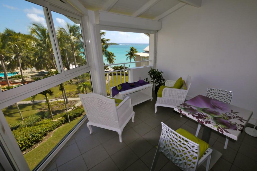 d'un balcon avec une table et des chaises et une vue sur l'océan. dans l'établissement Résidence de La Vieille Tour, au Gosier