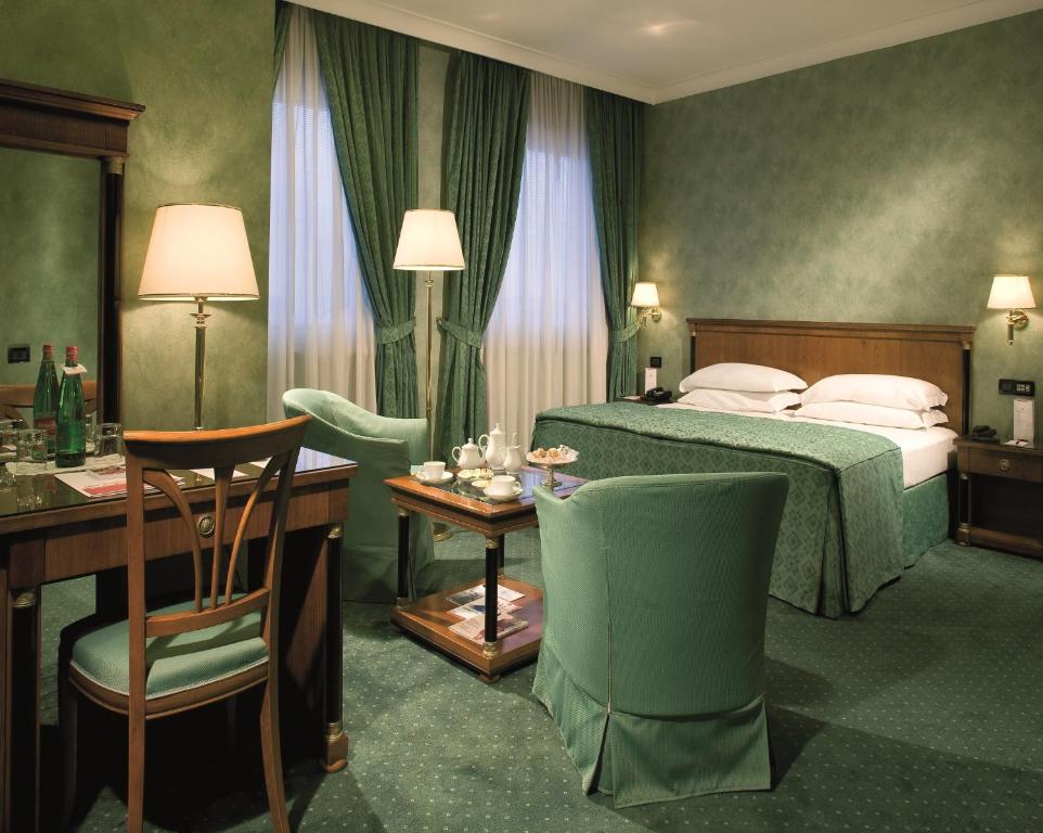 pokój hotelowy z łóżkiem, stołem i krzesłami w obiekcie Ramada by Wyndham Naples w mieście Neapol