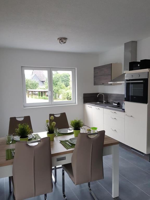a kitchen with a table and chairs and a kitchen with white cabinets at Ferienwohnung Julia in Sankt Aldegund