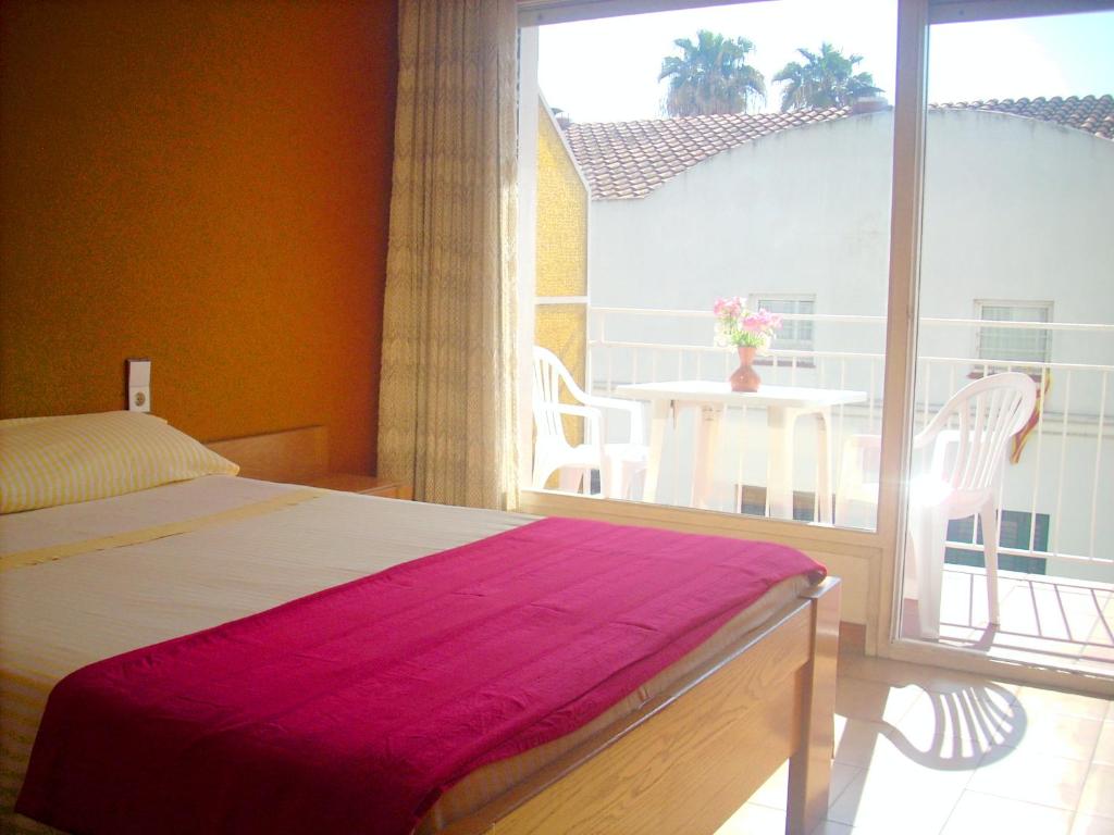 a bedroom with a bed and a balcony with a table at CALELLA DE LA COSTA ( Maresme - Costa Brava) in Calella