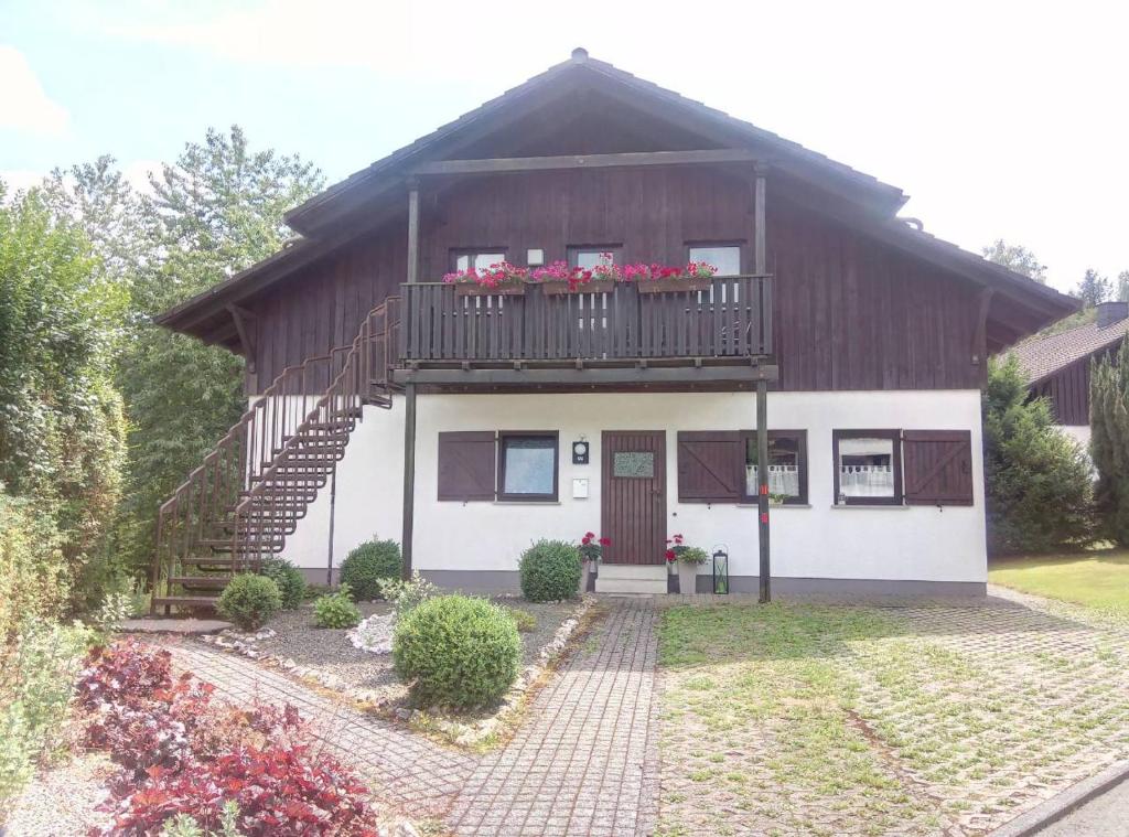 ein Haus mit einem Balkon mit Blumen darauf in der Unterkunft Ferienwohnung Martin in Thalfang