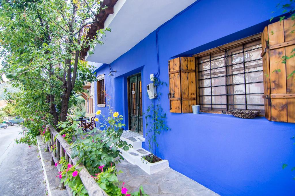 a blue building with a window and some plants at Dreaming House in Nea Vrasna