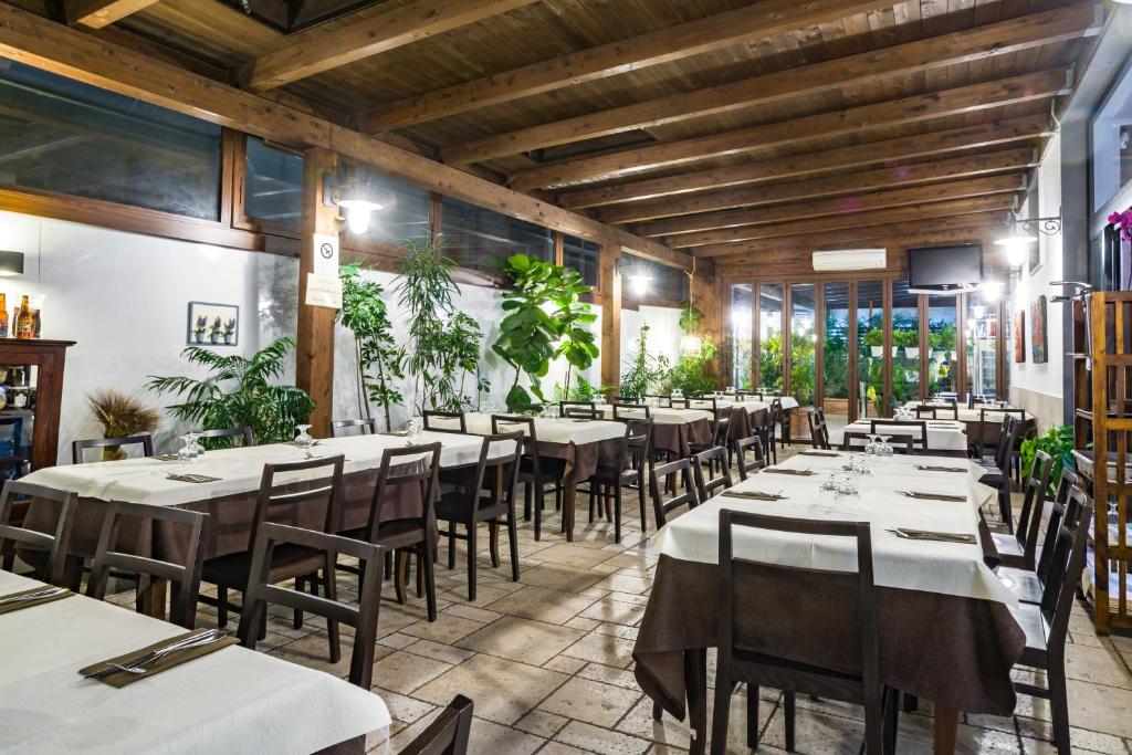 un ristorante con tavoli e sedie in una stanza di Hotel New Bari a Bitritto