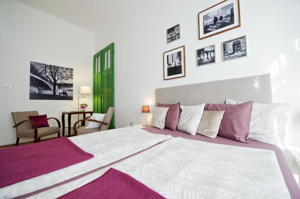 a bedroom with a large bed with purple and white sheets at Green Door Family Apartment in Budapest