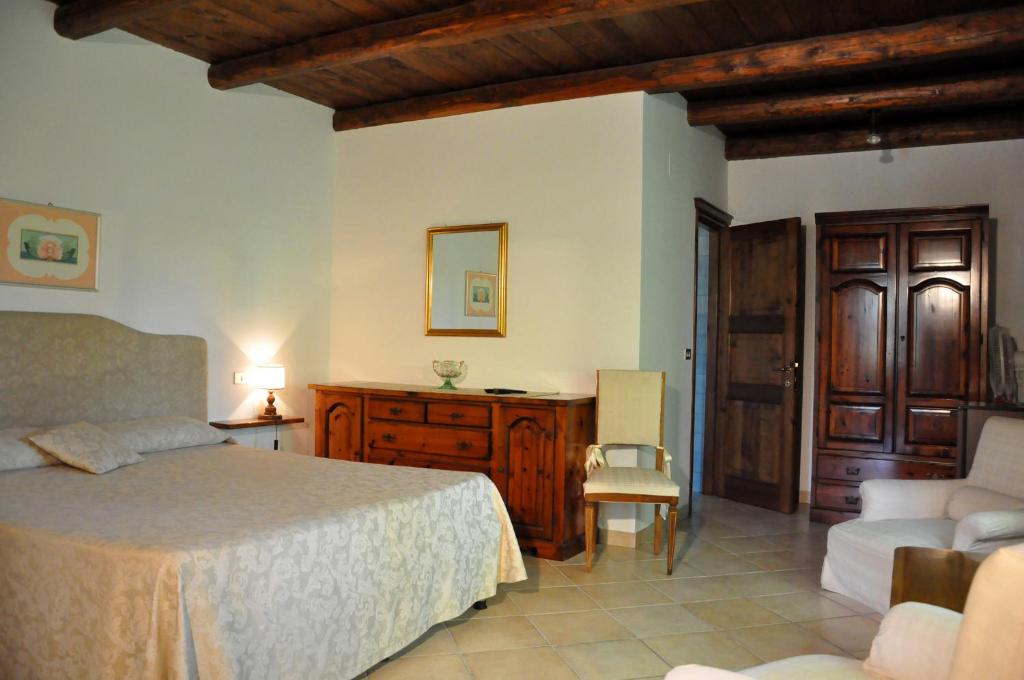 Agriturismo La Campana في Montefiore dellʼAso: غرفة نوم بسرير ومكتب وكرسي