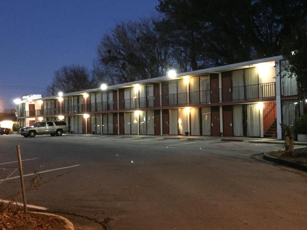 ein Parkplatz vor einem Gebäude nachts in der Unterkunft Cheshire Motor Inn in Atlanta