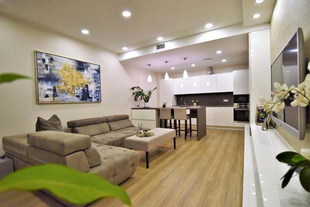 a living room and kitchen with a couch and a table at Europa Dream Apartment in Vilnius