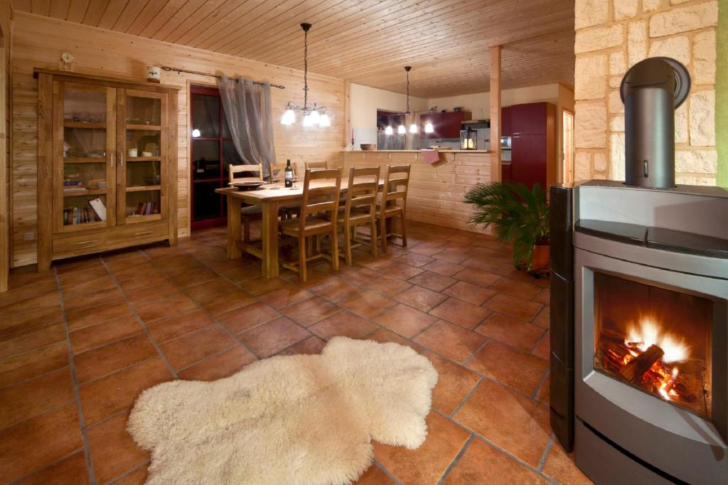 a living room with a fireplace and a table with chairs at Ferienhaus Buchholz in Warnitz