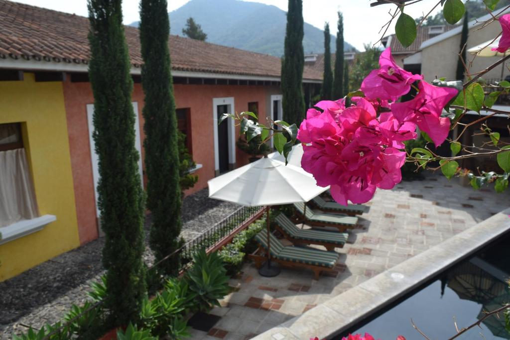 vistas a un patio con flores rosas y a un edificio en Villas Catalina, en Antigua Guatemala