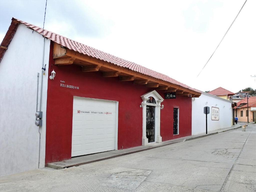 un edificio rojo y blanco con garaje en Regis Hotel Boutique, en Mineral del Monte