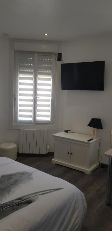 a bedroom with a bed and a flat screen tv at Val&#39; Appart 1 in Valenciennes
