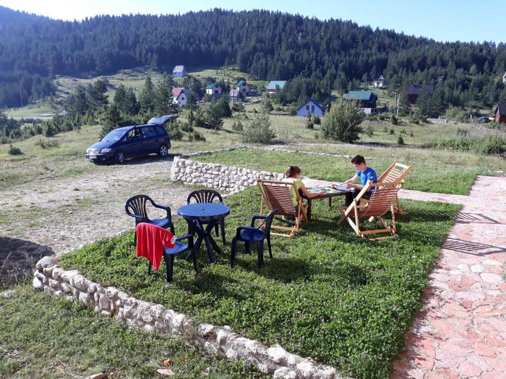a couple of people sitting in chairs at a table at Apartman Žabljak in Žabljak