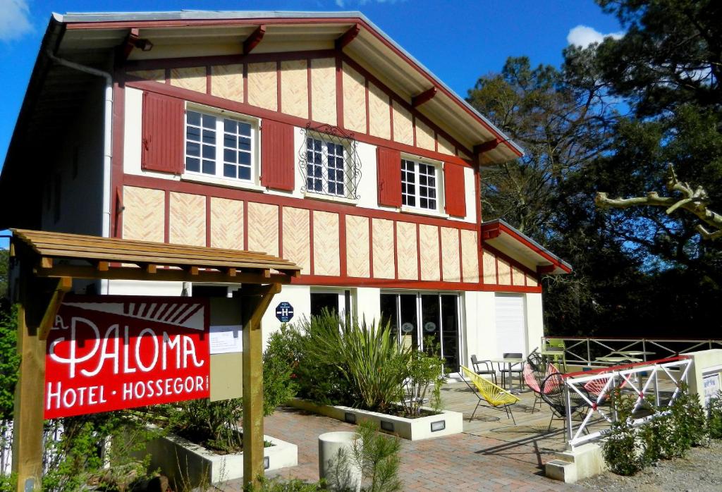 uma casa com um sinal em frente em Hôtel La Paloma em Hossegor