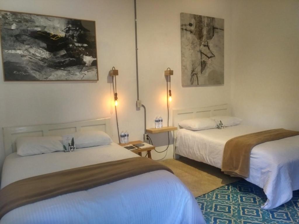 una habitación con dos camas en una habitación en La Tozi Hotel, en San Cristóbal de Las Casas