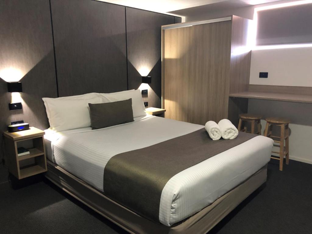 una camera da letto con un grande letto con due asciugamani di Huskisson Beach Motel a Huskisson