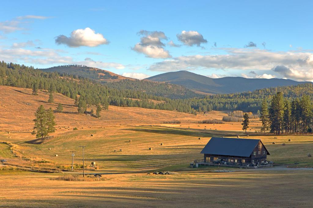 un granero en medio de un campo con montañas en Eden Valley Ranch en Oroville