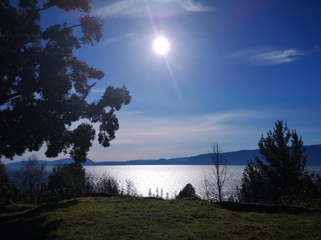 vistas a la puesta de sol sobre un lago en Cabañas Ayalén con vista al Lago, en Pucón