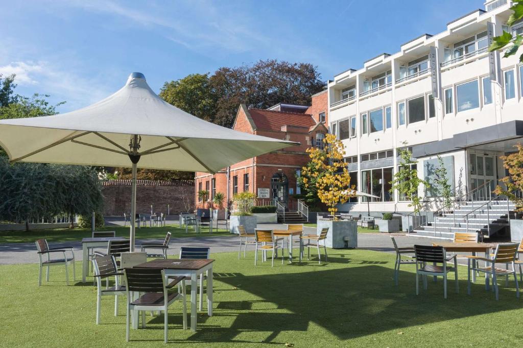a group of tables and chairs under a white umbrella at The Lincoln Hotel in Lincoln
