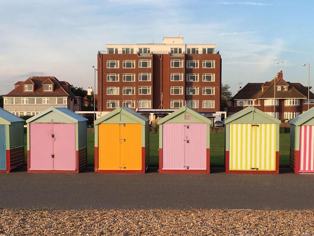 eine Reihe farbenfroher Strandhütten vor einem Gebäude in der Unterkunft Best Western Princes Marine Hotel in Brighton & Hove