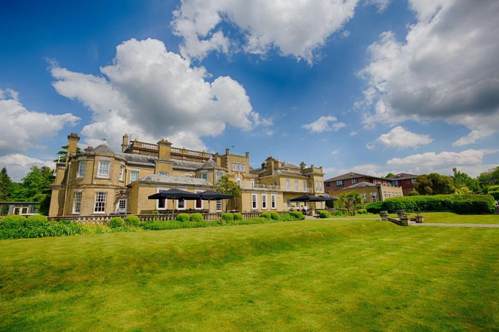 una grande casa con un prato verde davanti di Best Western Chilworth Manor Hotel a Southampton