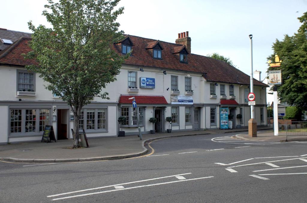 una calle en una ciudad con un edificio blanco en Best Western Ship Hotel en Weybridge