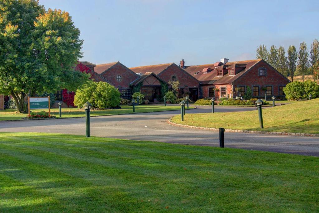 a street in front of a house with a driveway at Bernwood Park Hotel in Boarstall