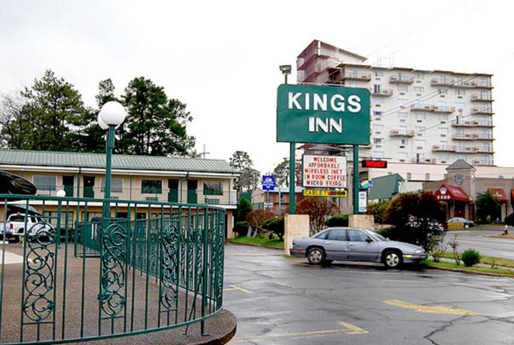 een Kings Inn bord op een parkeerplaats met een auto bij Kings Inn Hot Springs in Hot Springs