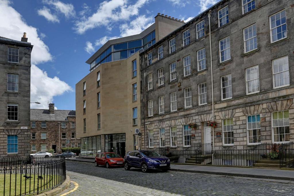 a building with two cars parked in front of it at Ten Hill Place in Edinburgh