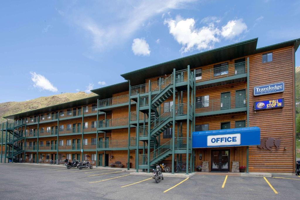 un gran edificio con motocicletas estacionadas en un estacionamiento en Travelodge by Wyndham Gardiner Yellowstone Park North Entr, en Gardiner