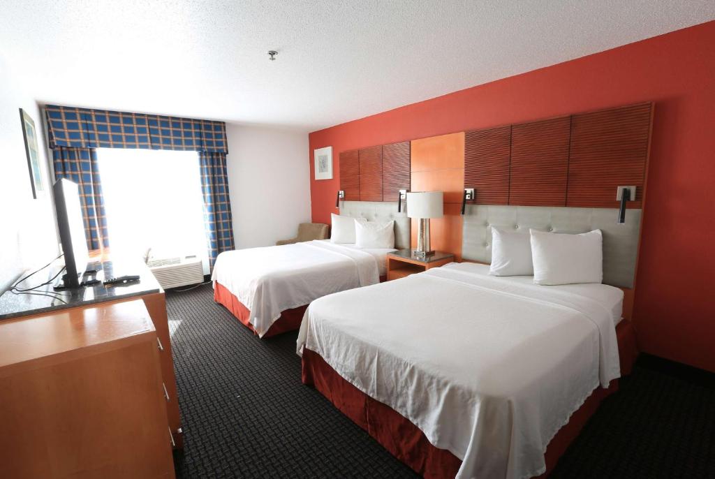 a hotel room with two beds and a window at Days Inn by Wyndham Calumet Park in Calumet Park