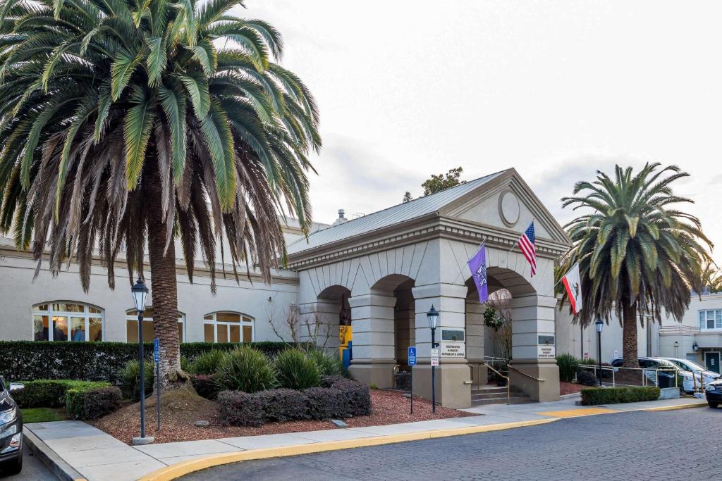 um edifício com uma palmeira em frente em Lions Gate Hotel em Sacramento