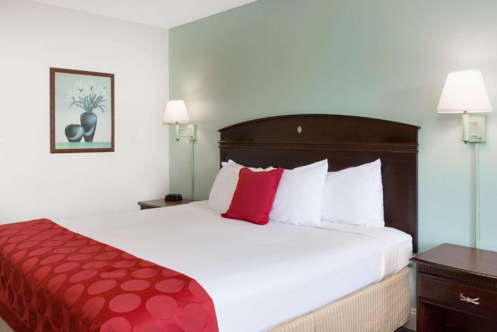 a hotel room with a large bed with red pillows at Ramada by Wyndham Pelham in Pelham