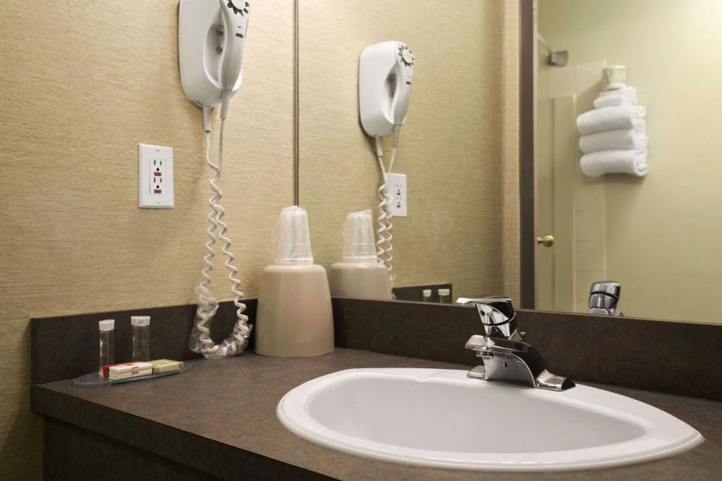 a bathroom counter with a sink and a phone at Super 8 by Wyndham Revelstoke BC in Revelstoke