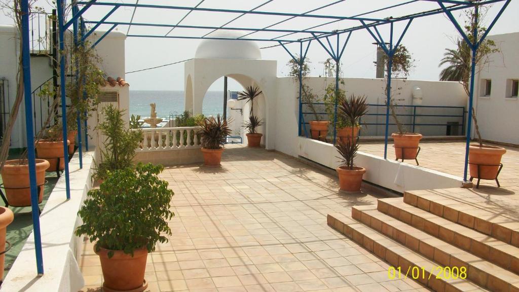einen Balkon mit Topfpflanzen und Treppen auf einem Gebäude in der Unterkunft Virgen del Mar Holidays in Mojácar
