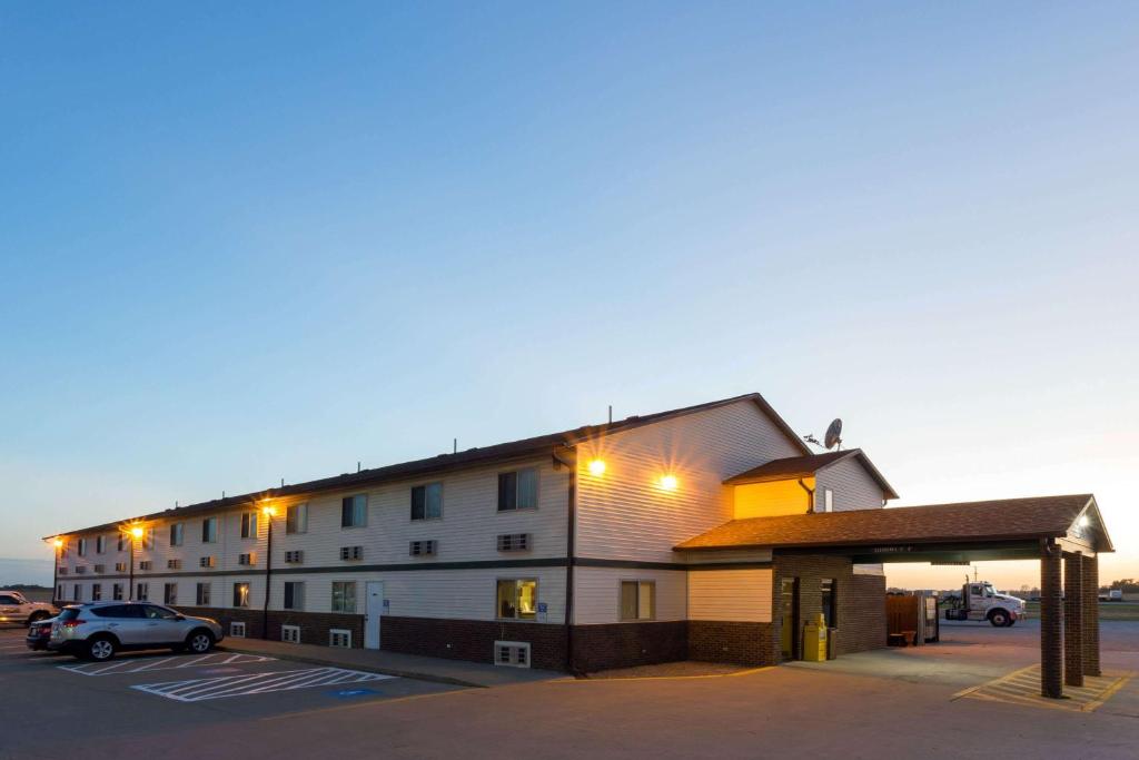 a building with a parking lot in front of it at Super 8 by Wyndham Mendota in Mendota