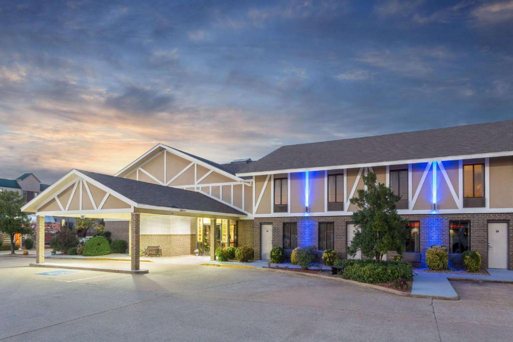 budynek z niebieskimi światłami z przodu w obiekcie Super 8 by Wyndham Bentonville w mieście Bentonville