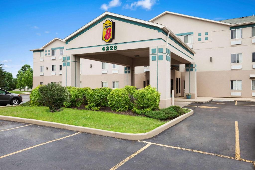 a hotel with a sign on the front of a parking lot at Super 8 by Wyndham Aurora/Naperville Area in Aurora