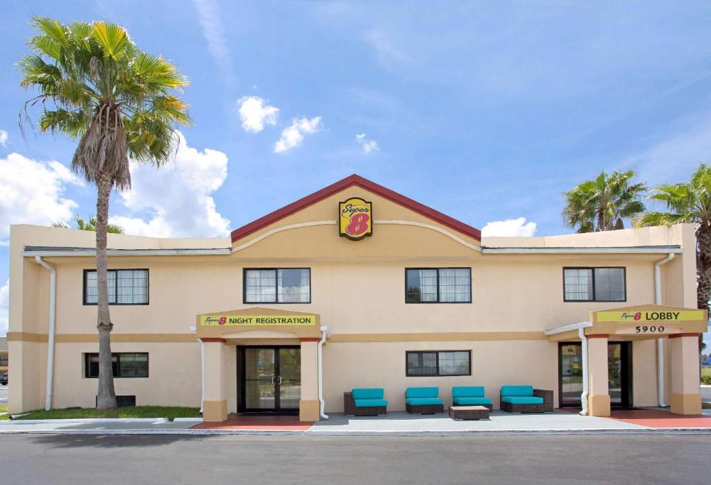 een hotel met blauwe stoelen buiten bij Super 8 by Wyndham Orlando International Drive in Orlando