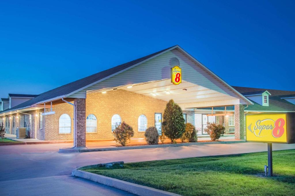 a building with a sign in front of it at Super 8 by Wyndham Big Cabin/Vinita Area in Vinita