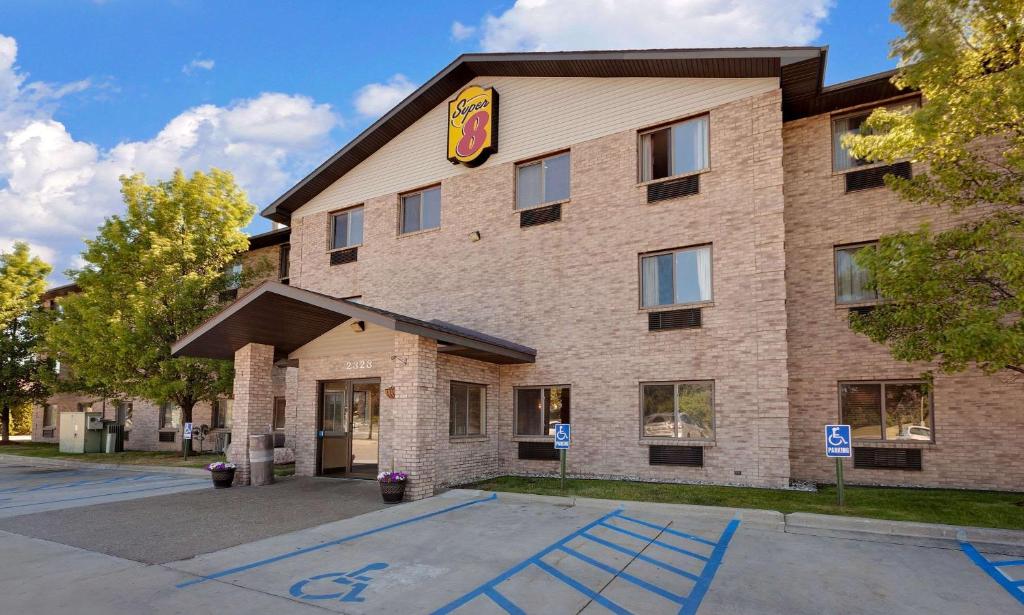 a large brick building with a sign on it at Super 8 by Wyndham Mt. Pleasant in Mount Pleasant