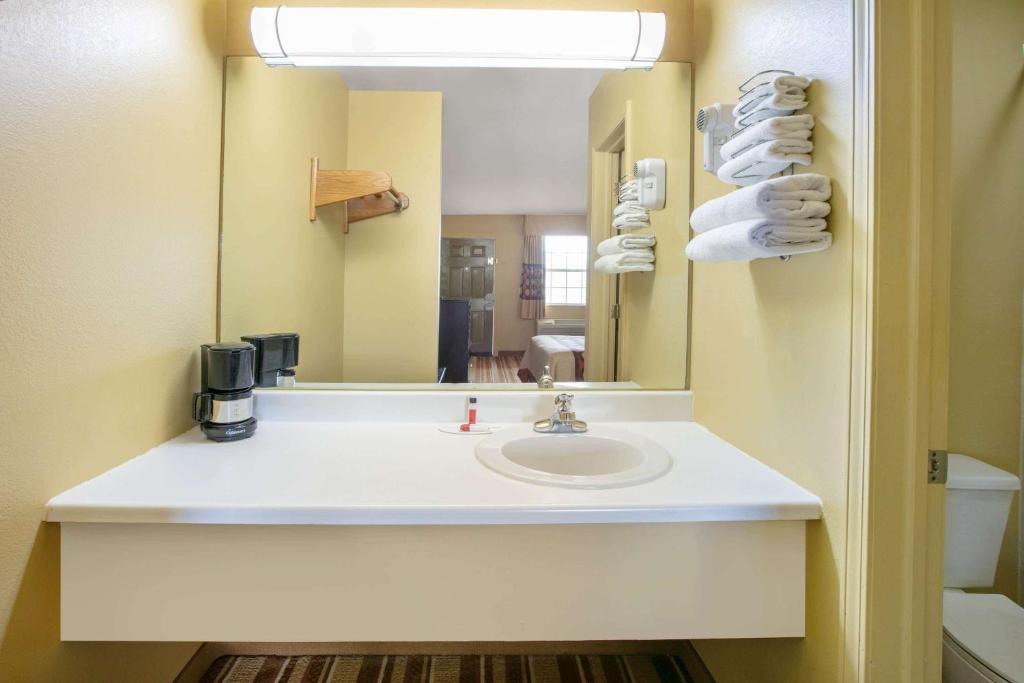 a bathroom with a sink and a mirror at Super 8 by Wyndham Big Cabin/Vinita Area in Vinita