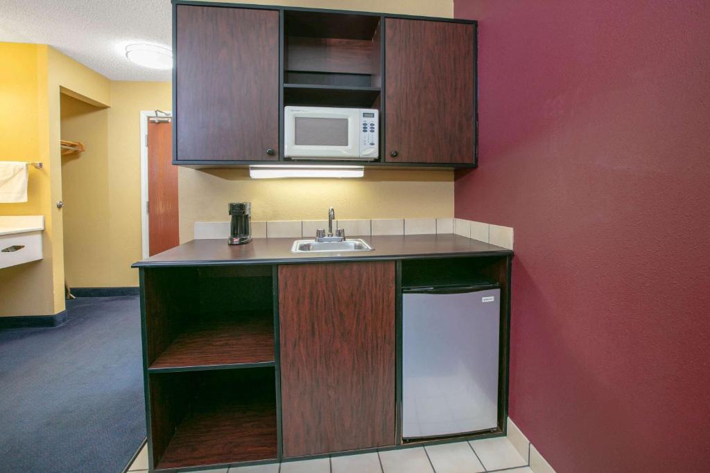 a kitchen with a sink and a microwave at Super 8 by Wyndham Big Cabin/Vinita Area in Vinita
