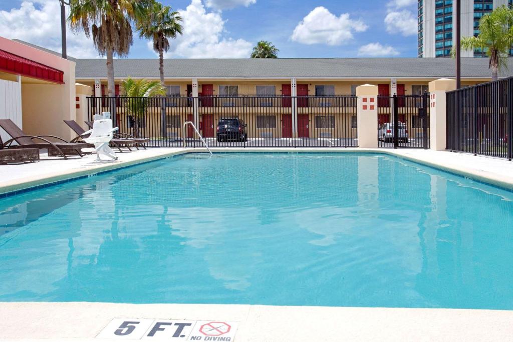 uma grande piscina em frente a um hotel em Super 8 by Wyndham Orlando International Drive em Orlando