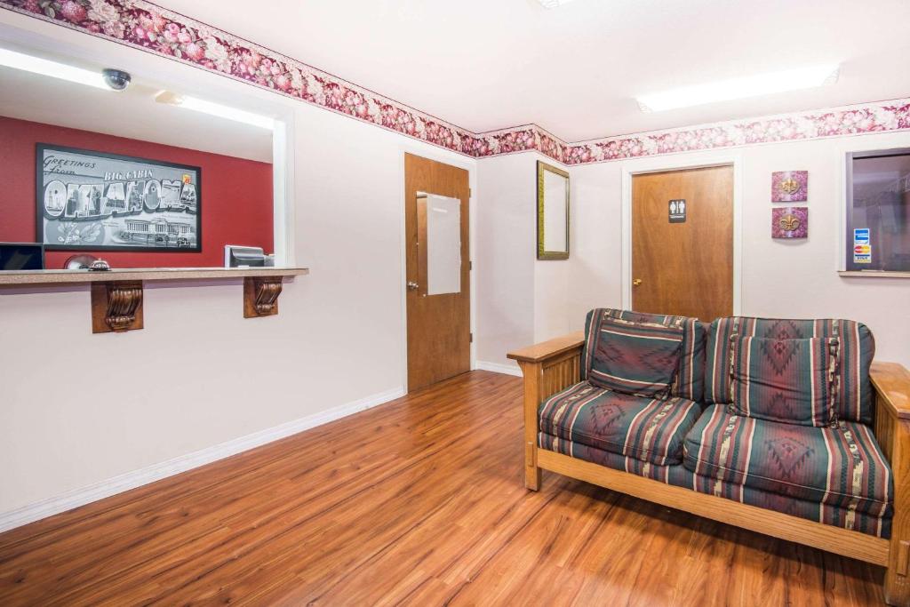 a living room with a couch and a television at Super 8 by Wyndham Big Cabin/Vinita Area in Vinita