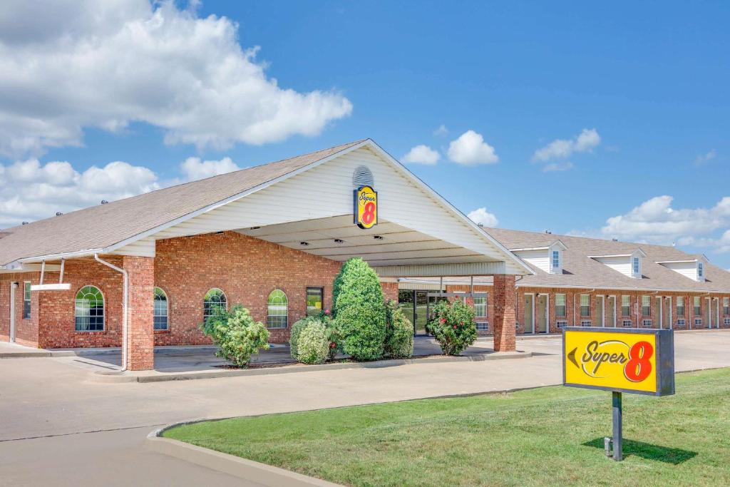 a building with a sign in front of it at Super 8 by Wyndham Big Cabin/Vinita Area in Vinita