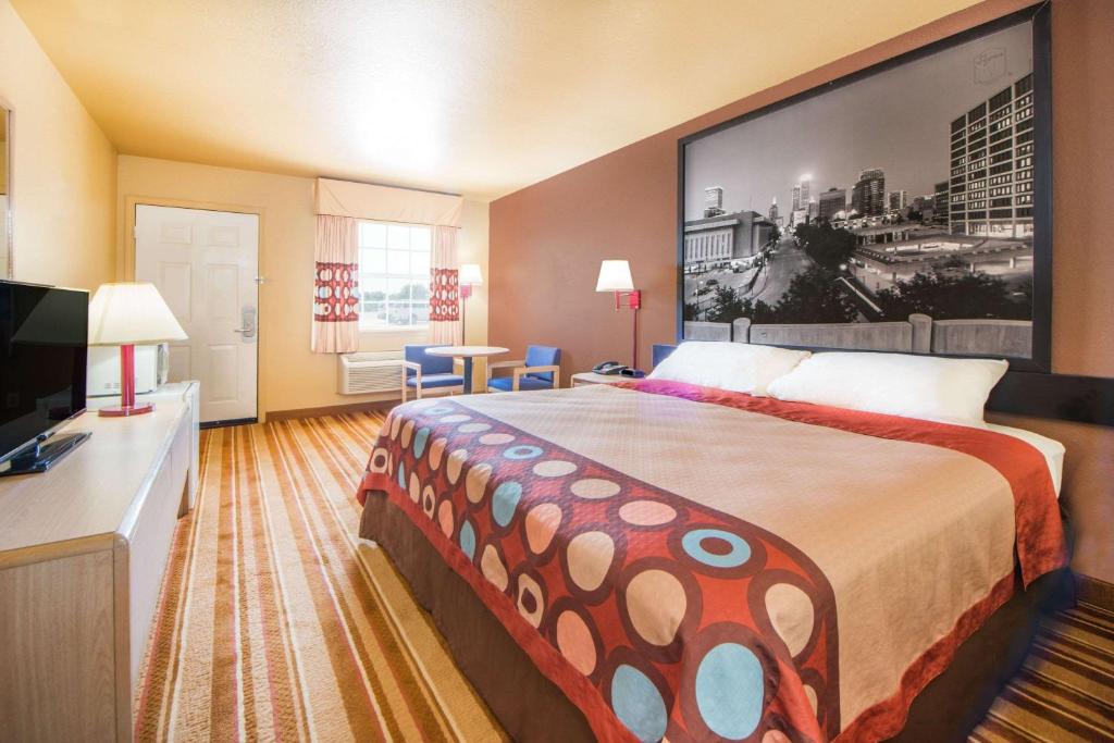 a hotel room with a large bed and a flat screen tv at Super 8 by Wyndham Big Cabin/Vinita Area in Vinita
