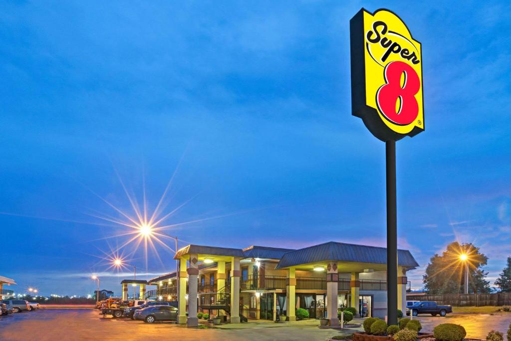 a sign for a speed eight gas station at night at Super 8 by Wyndham Shawnee in Shawnee