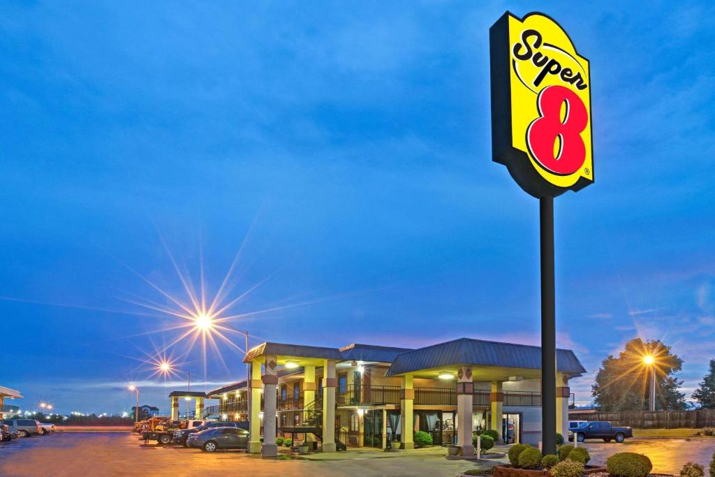 ein Schild für eine Speed-Eight-Tankstelle in der Nacht in der Unterkunft Super 8 by Wyndham Shawnee in Shawnee