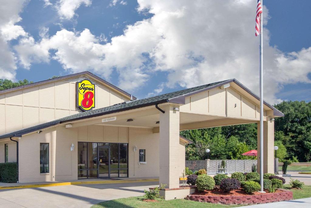a mcdonalds restaurant with a flag in front of it at Super 8 by Wyndham Clarksville AR in Clarksville
