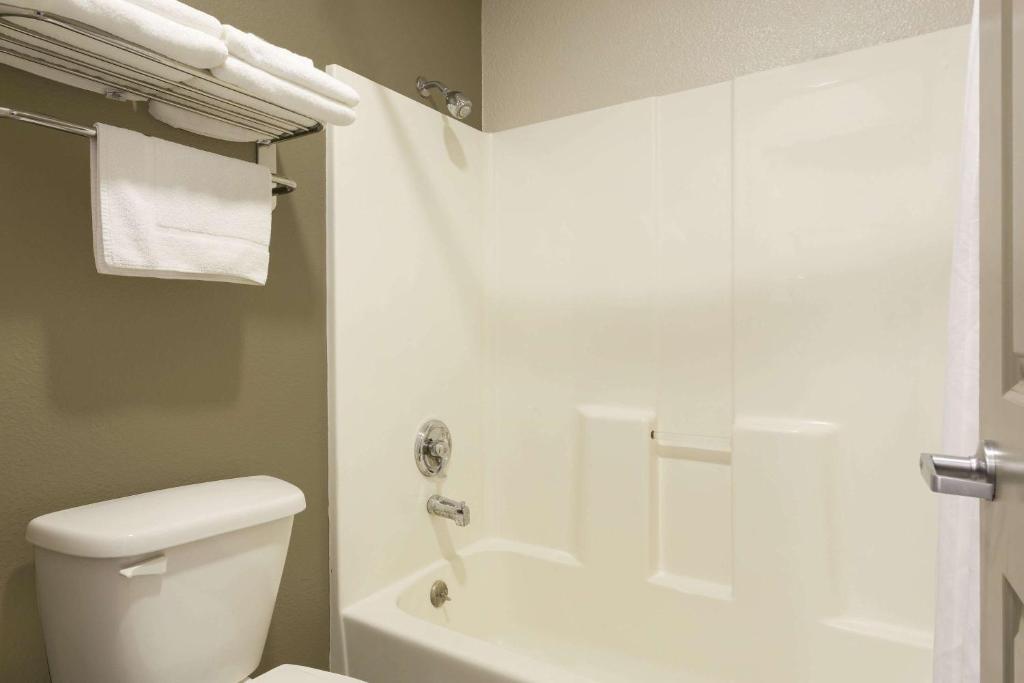 a bathroom with a white toilet and a shower at Super 8 by Wyndham Fortuna in Fortuna